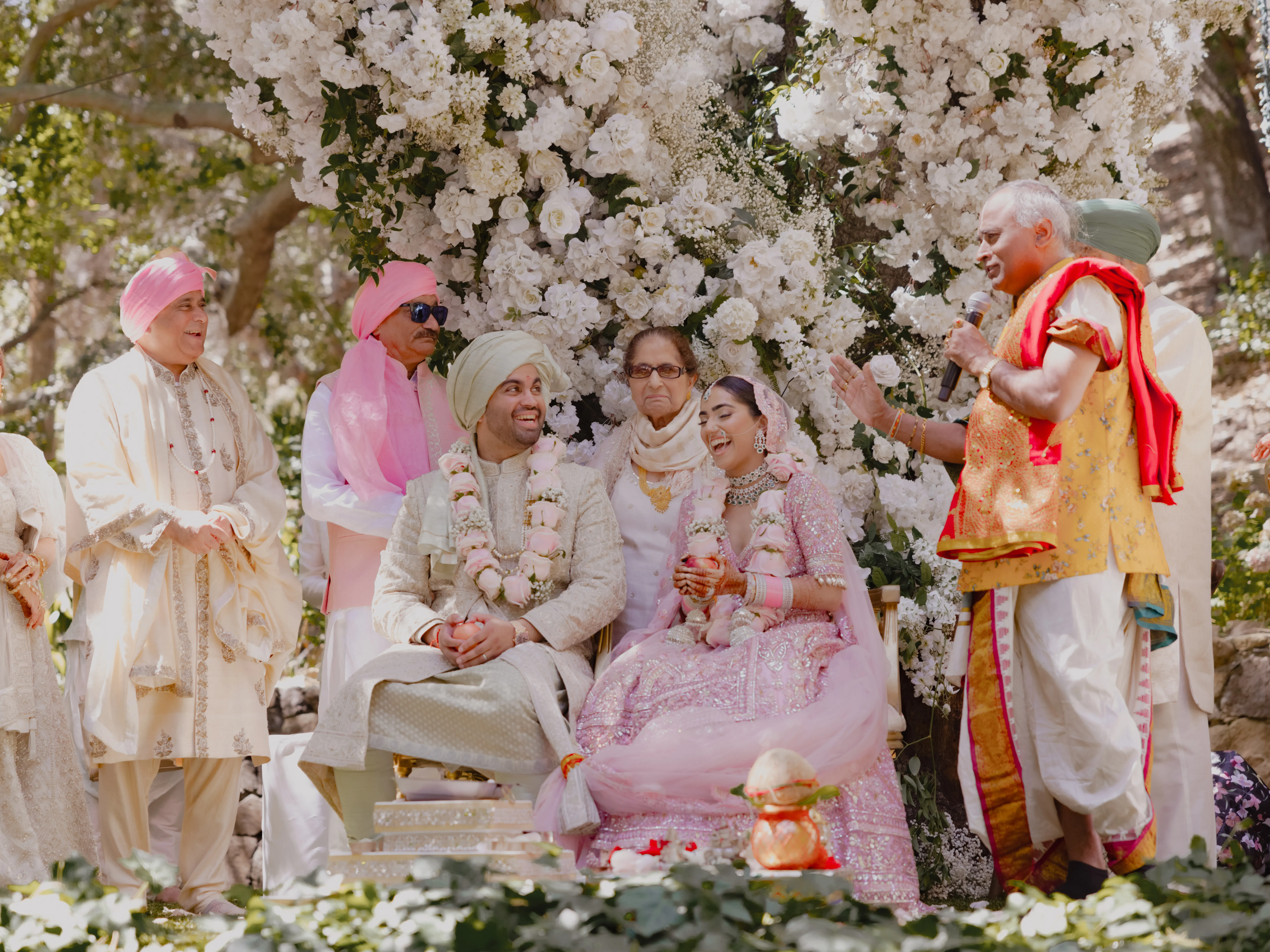 マリブのおとぎ話のようなインドの結婚式で、花嫁はピンク、ゲストはアイボリーを着た